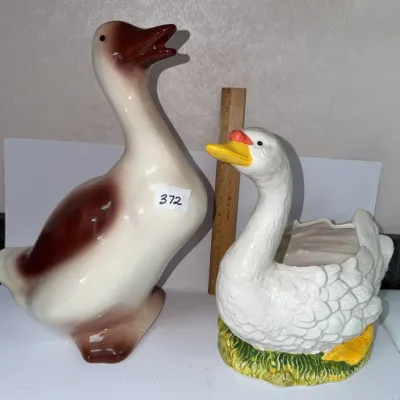 Sale Photo Thumbnail #646: Pair of vintage glazed ceramic waterfowl figures, including a large standing brown-and-white duck statuette and a textured white swan planter.