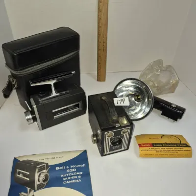 Sale Photo Thumbnail #309: Vintage photography group including a Bell & Howell 430 Autoload Super 8 movie camera with case and manual, a Kodak Brownie Target SIX-20 box camera, and a flash attachment.