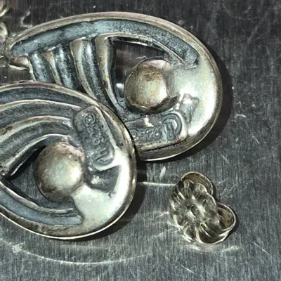 Sale Photo Thumbnail #862: Pair of vintage sterling silver drop earrings featuring a maker's mark and 925 stamp, shown with a butterfly earring back.