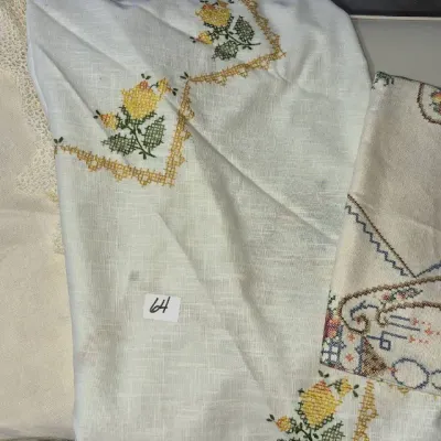 Sale Photo Thumbnail #97: Selection of vintage embroidered linen table runners and cloths featuring floral hand-stitched details and lace edging.