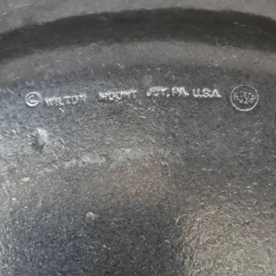 Sale Photo Thumbnail #657: Close-up detail of a Wilton Columbia, PA, USA maker's mark stamped on a pewter or Armetale metal piece.