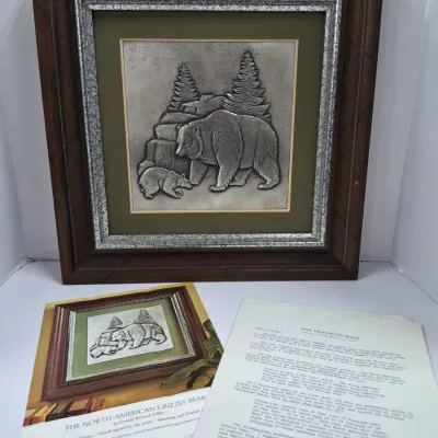 Sale Photo Thumbnail #597: Framed Franklin Mint sterling silver embossed wall sculpture titled 'The North American Grizzly Bear' by Donald Richard Miller, complete with original brochure and documentation.