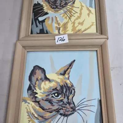 Sale Photo Thumbnail #207: Pair of vintage paint-by-number framed portraits featuring Siamese cats in light wood frames.