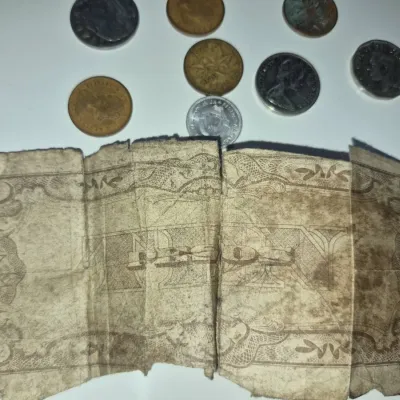 Sale Photo Thumbnail #145: Heavily worn vintage 10 Pesos paper currency note shown alongside an assortment of international coins.