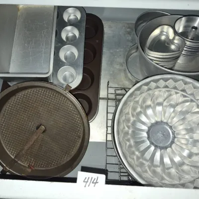 Sale Photo Thumbnail #727: Assortment of vintage bakeware including aluminum bundt pans, muffin tins, a loaf pan, springform pan, and mini heart molds inside a drawer.