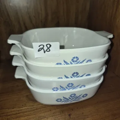 Sale Photo Thumbnail #44: Stack of four vintage CorningWare Blue Cornflower square casserole dishes resting on a wooden shelf.