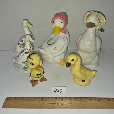 Sale Photo Thumbnail #439: Collection of five vintage ceramic duck and chick figurines, including a planter with a pink bonnet and a goose wearing a straw hat.
