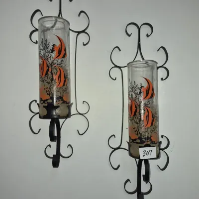Sale Photo Thumbnail #542: Pair of vintage mid-century wrought iron wall sconces featuring glass hurricane cylinders decorated with orange and black angelfish graphics.