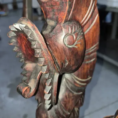 Sale Photo Thumbnail #125: Hand-carved wooden dragon sculpture featuring intricate teeth and scale details in a dark wood finish.