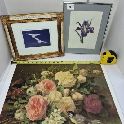 Sale Photo Thumbnail #603: Collection of three framed and unframed artworks, featuring a large unframed floral still life print with a songbird, a framed needlepoint of a purple iris, and a framed print of gulls in flight.
