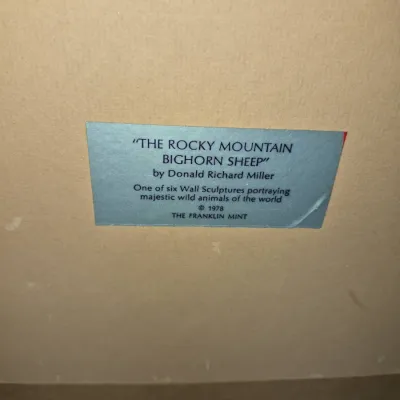 Sale Photo Thumbnail #602: Original label for a 1978 Franklin Mint wall sculpture titled "The Rocky Mountain Bighorn Sheep" by Donald Richard Miller.