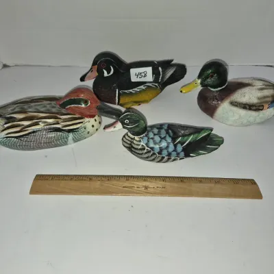 Sale Photo Thumbnail #792: Collection of four vintage hand-painted wooden duck decoys in various duck species and sizes, shown next to a 12-inch ruler for scale.