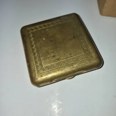 Sale Photo Thumbnail #338: Vintage square brass powder compact featuring an embossed Greek key pattern border with light surface patina.