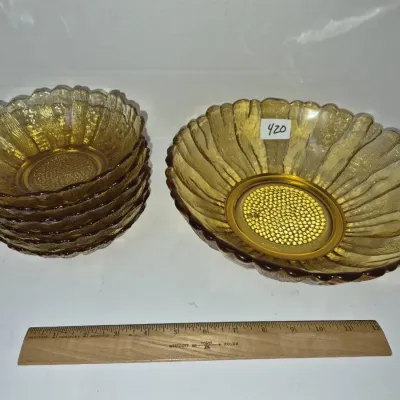 Sale Photo Thumbnail #735: Vintage amber glass berry set featuring one large serving bowl and five matching smaller individual bowls with sunflower-style textured petals.