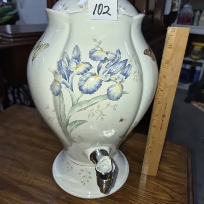 Sale Photo Thumbnail #162: Ceramic beverage dispenser featuring a hand-painted floral motif with blue irises and butterflies, complete with a silver-tone spigot and lid.
