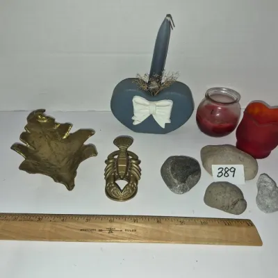 Sale Photo Thumbnail #681: Collection of decorative smalls including a brass leaf tray, brass lobster clip, heart-shaped candle holder, votive candles, and decorative stones.