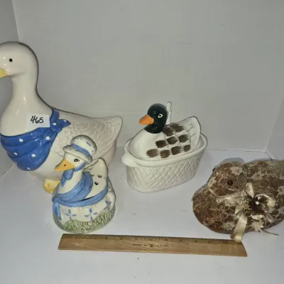Sale Photo Thumbnail #801: Collection of four duck-themed decor items, including ceramic figurines, lidded trinket boxes, and a fabric-wrapped duck statue, shown with a 12-inch wooden ruler for scale.