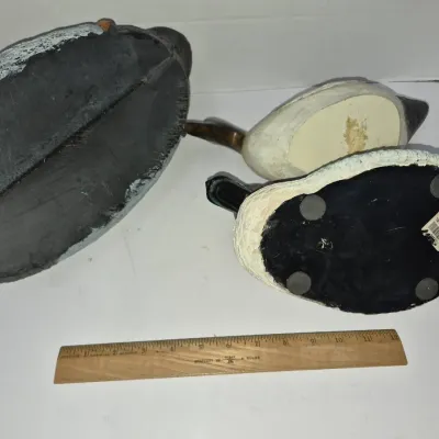 Sale Photo Thumbnail #789: Underside view of three vintage duck decoys and figurines shown with a twelve-inch wooden ruler for scale.