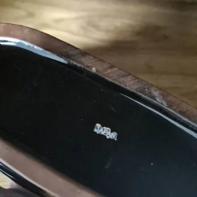 Sale Photo Thumbnail #31: Underside of a ceramic or wooden item featuring an original blue and white "Japan" sticker, indicating mid-century import origin.