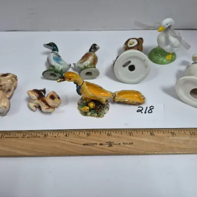 Sale Photo Thumbnail #375: Collection of vintage animal figurines, including porcelain ducks, small squirrels, an owl, and a yellow hinged trinket box.