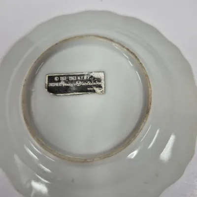 Sale Photo Thumbnail #426: Underside of a 1964-1965 New York World's Fair souvenir porcelain plate featuring the original foil label.