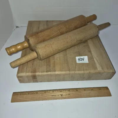 Sale Photo Thumbnail #741: Vintage thick butcher block cutting board accompanied by two wooden rolling pins, showing natural wear from use.
