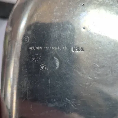 Sale Photo Thumbnail #578: Close-up of maker's marks stamped on the underside of a vintage Wilton Armetale metal piece from Columbia, Pennsylvania.