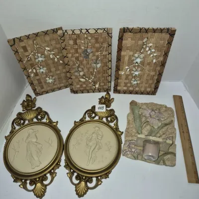 Sale Photo Thumbnail #768: Collection of vintage decor items, including three woven bamboo shell art plaques, a pair of ornate oval brass-framed cameo wall art pieces, and a floral resin wall sconce.