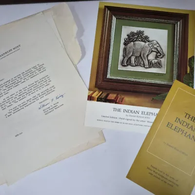 Sale Photo Thumbnail #588: The Franklin Mint collector ephemera set for "The Indian Elephant" silver wall sculpture by Donald Richard Miller, including a letter, promotional print, and informational booklet.