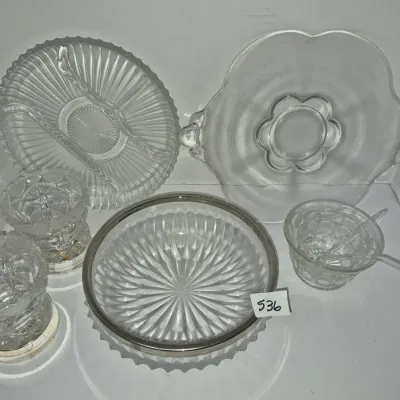 Sale Photo Thumbnail #925: Collection of vintage clear glass serveware including a silver-rimmed bowl, divided relish trays, small footed dishes, and a sauce cup with ladles.