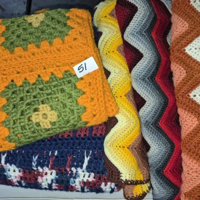 Sale Photo Thumbnail #81: Collection of handmade vintage crocheted afghans, featuring granny square and chevron chevron chevron patterns in earth tones and vibrant colors.