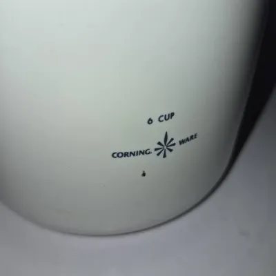 Sale Photo Thumbnail #738: Vintage white Corning Ware 6-cup vessel featuring the classic blue starburst logo, showing light wear.