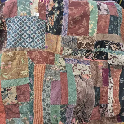 Sale Photo Thumbnail #75: Handmade crazy quilt featuring a patchwork design of mixed textiles including velvet, brocade, and corduroy fabrics in rich earth tones.