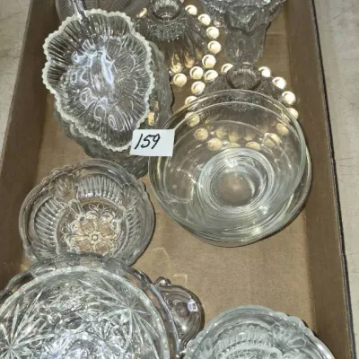 Sale Photo Thumbnail #277: Box lot of assorted clear press glass tableware, including small bowls, covered candy dishes, candle holders, and leaf-shaped relish trays.