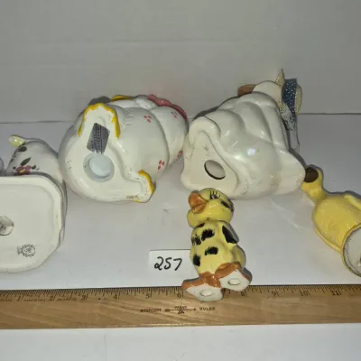 Sale Photo Thumbnail #440: Collection of five vintage duck and bird ceramic figurines, including salt shaker pairs and hand-painted novelties, displayed alongside a wooden ruler for scale.