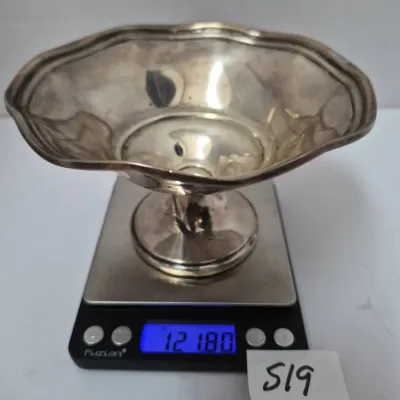 Sale Photo Thumbnail #895: Small sterling silver scalloped bowl on a pedestal, sitting on a digital scale displaying 121.80 grams.