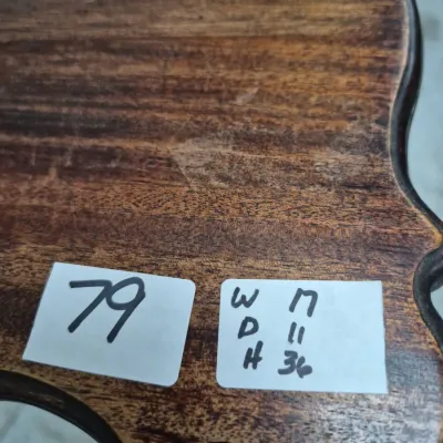 Sale Photo Thumbnail #127: Close-up of a dark stain wooden tabletop with scalloped edges, featuring sale tags indicating item lot #79 and dimensions.