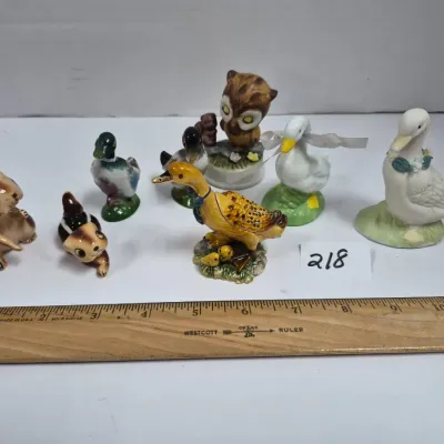 Sale Photo Thumbnail #374: Collection of eight vintage ceramic animal figurines, including ducks, chipmunks, and an owl, shown next to a ruler for scale.