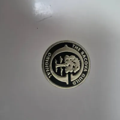 Sale Photo Thumbnail #780: Close-up detail of a circular emblem reading "The Bacova Guild Original" featuring a tree motif.