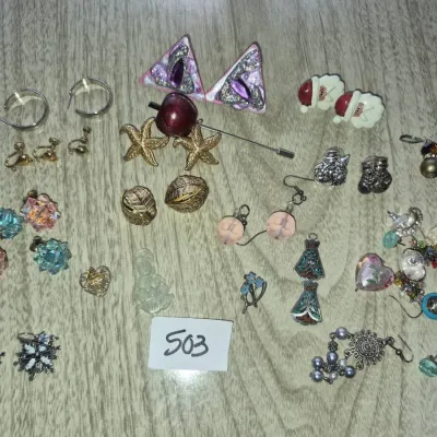 Sale Photo Thumbnail #866: Assorted vintage costume jewelry lot featuring various pierced and clip-on earrings, pins, and small pendants.