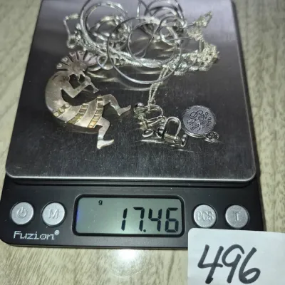 Sale Photo Thumbnail #853: Collection of sterling silver jewelry including a Kokopelli pendant, chain, hoop earrings, screw-back earrings, and a Las Vegas charm, weighing 17.46 grams total.