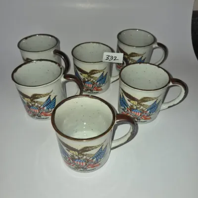 Sale Photo Thumbnail #579: Set of six vintage stoneware coffee mugs featuring a patriotic bald eagle and American flag motif, commemorating the United States Bicentennial.