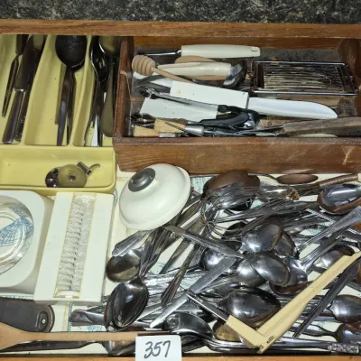 Sale Photo Thumbnail #620: Kitchen drawer filled with vintage utensils, including metal spoons, wisps, knives, a honey dipper, and plastic organizers.