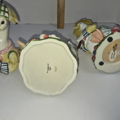Sale Photo Thumbnail #308: Collection of Fitz and Floyd ceramic duck figurines, including a music box labeled "Rain Rain Go Away" and a stamped piece from 1990.