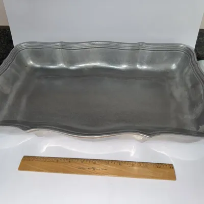 Sale Photo Thumbnail #642: Large vintage pewter or aluminum rectangular serving platter with side handles and a scalloped rim, shown with a 12-inch wooden ruler for scale.