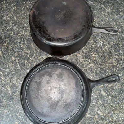 Sale Photo Thumbnail #651: Two vintage cast iron skillets, both size number 8, showing heavy seasoning and light surface wear.