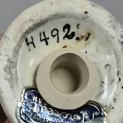 Sale Photo Thumbnail #220: Underside of a vintage ceramic shaker showing a rubber stopper, hand-painted model number 'H 492', and a foil maker's sticker labeled 'Japan'.