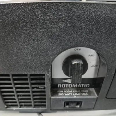 Sale Photo Thumbnail #135: Detail view of a vintage Sawyer's Rotomatic slide projector control dial with off, fan, and lamp settings.