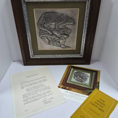 Sale Photo Thumbnail #592: Framed Franklin Mint silver bas-relief plaque depicting "The Asian Snow Leopard" by Donald Richard Miller, complete with original documentation, certificate, and booklet.