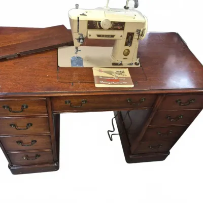 Sale Photo Thumbnail #52: Vintage Singer Slant-O-Matic 401 sewing machine built into a wooden desk cabinet with multiple storage drawers.